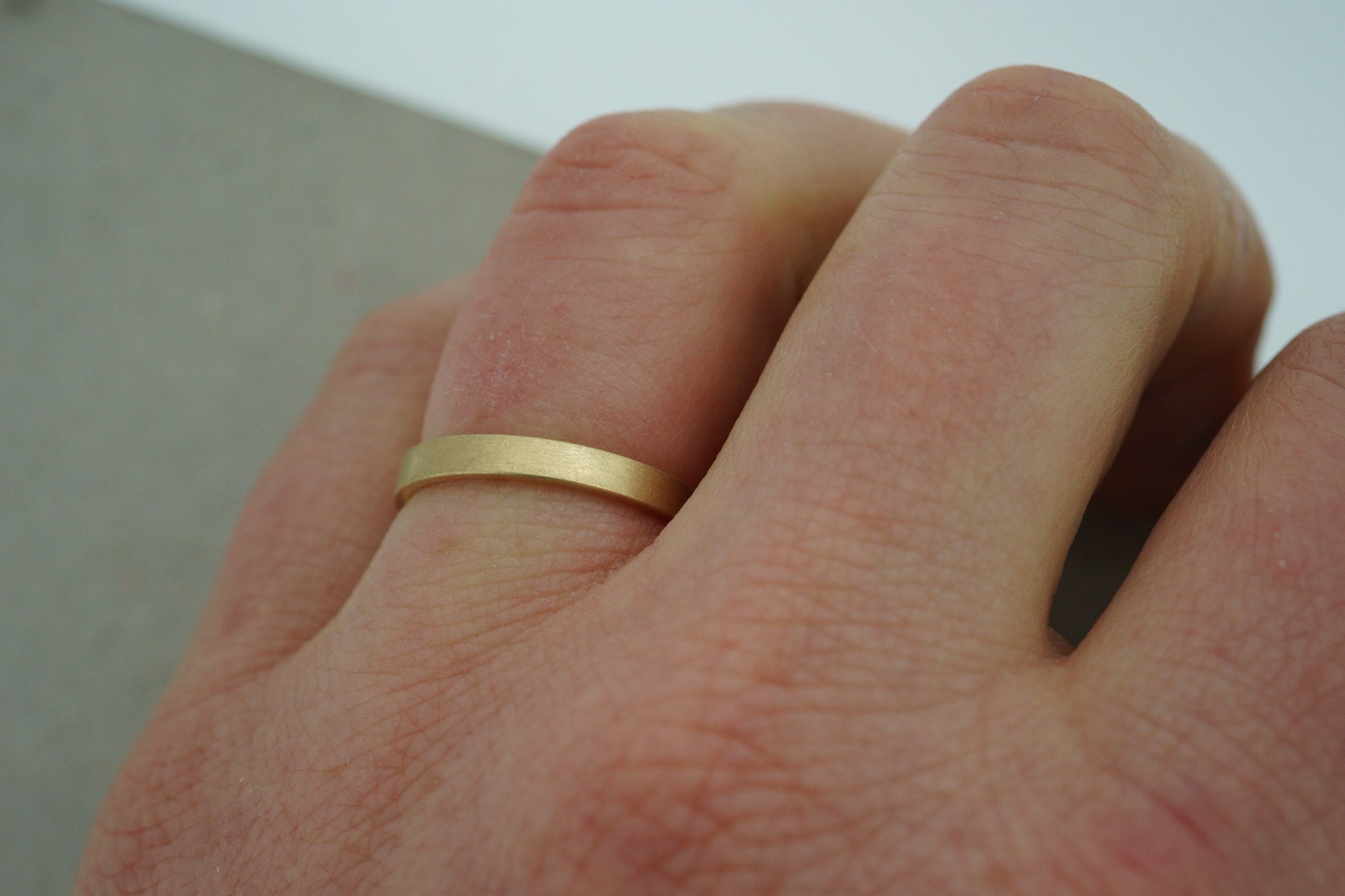Schmaler goldener eckiger Trauring