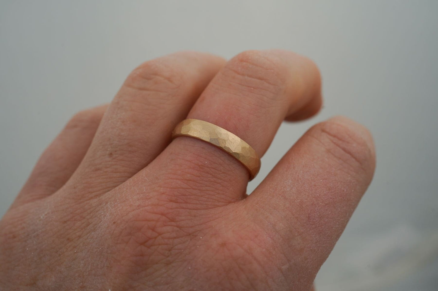 Gelbgold Ehering gehämmert am Finger