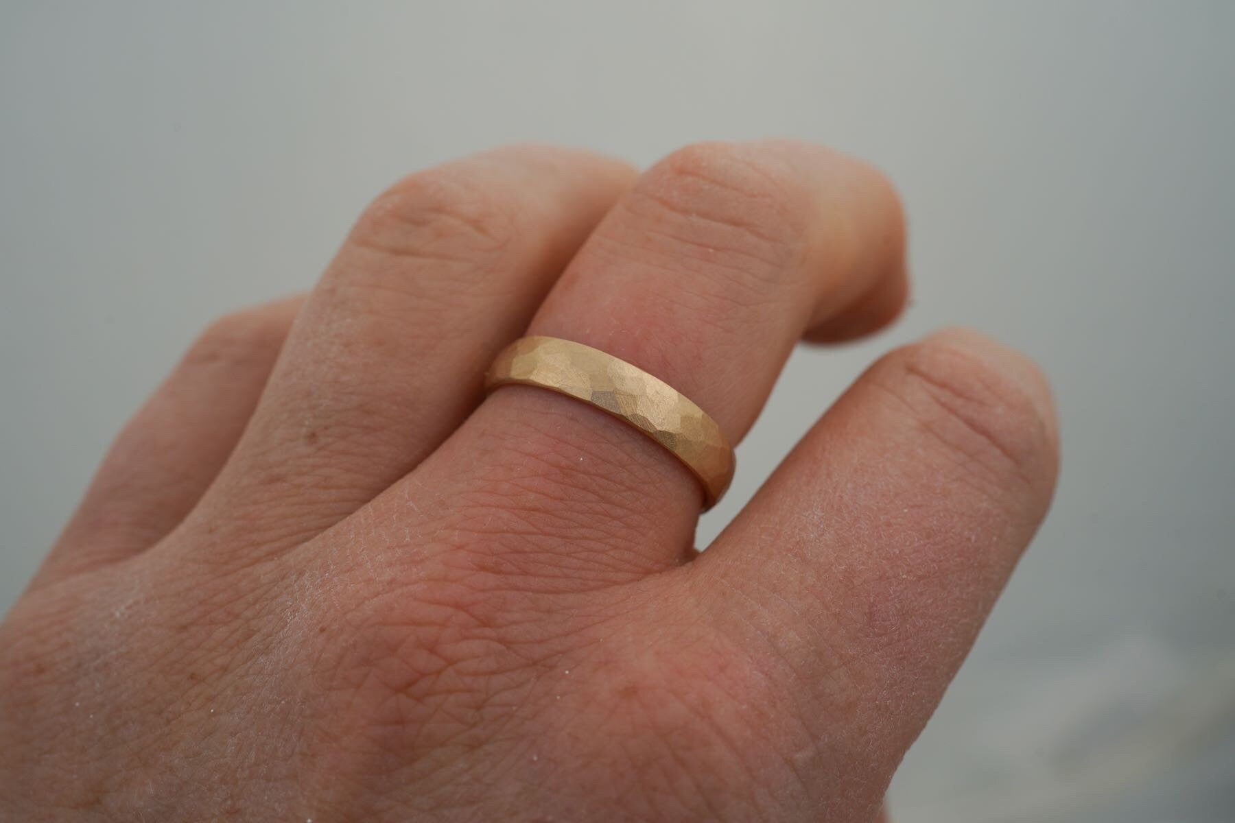 Gelbgold Ehering gehämmert am Finger